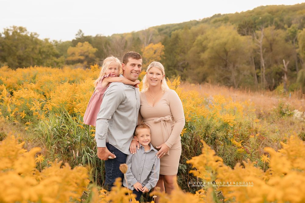 Family portrait in a field of yellow wildflowers during golden hour. Kendall Kuss Photography, Waukesha Wisconsin outdoor family photos