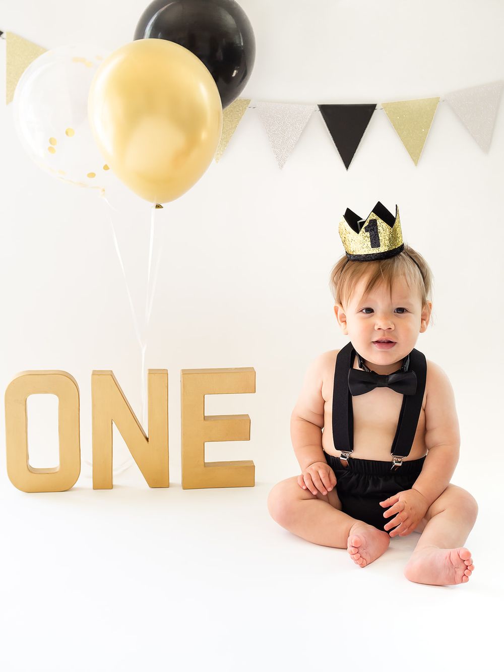 cake smash first birthday. one year old boy with balloons and birthday crown. Sonoma county