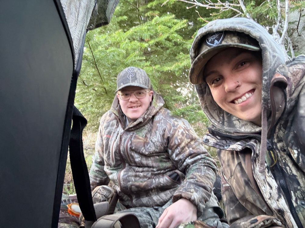 People wearing camouflage hunting gear smile together in a series of selfie-style photos taken outdoors.