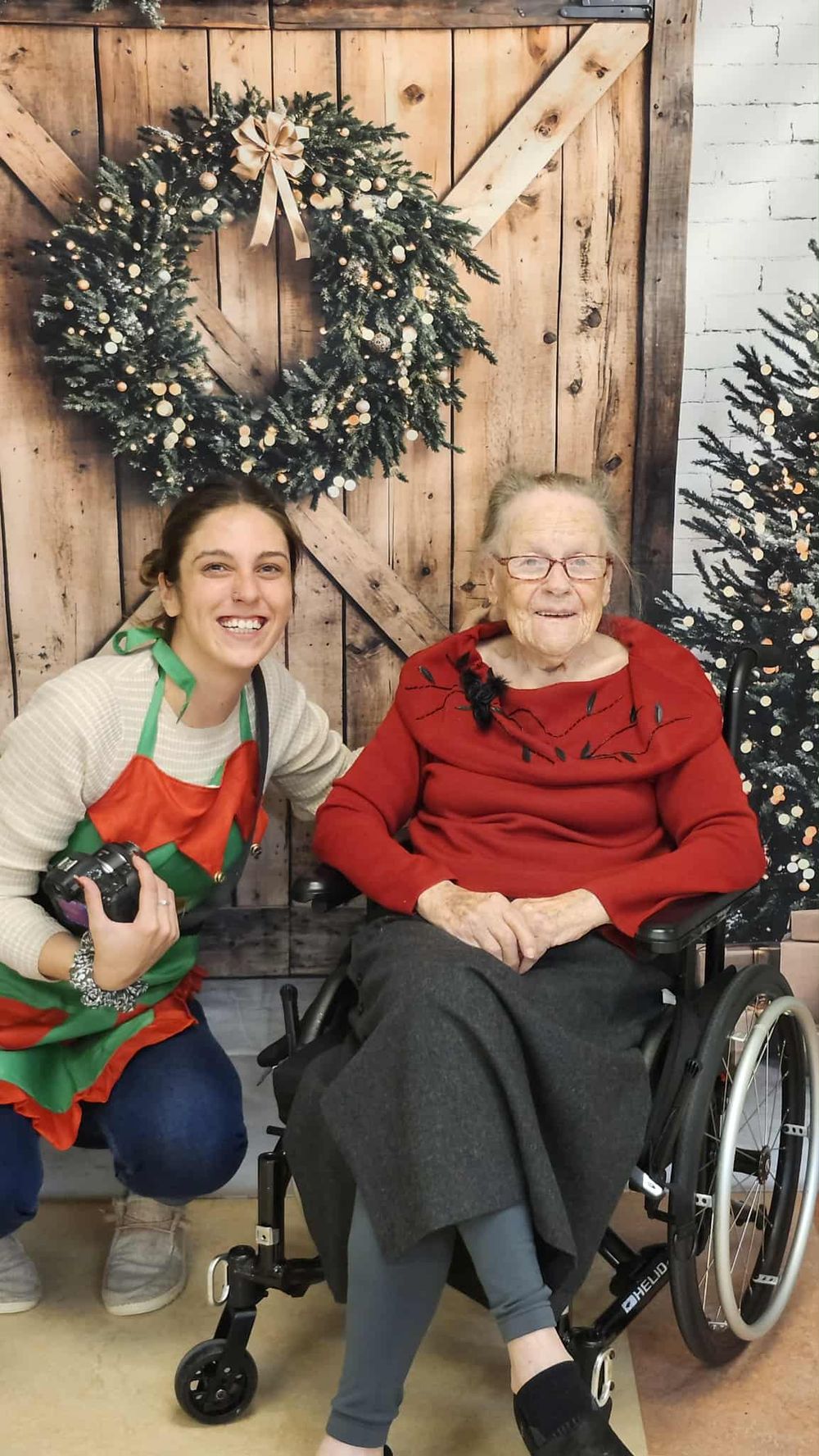 Three holiday photos show two people sitting together in front of a rustic wooden backdrop with Christmas wreaths and trees.