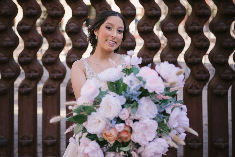 girl holding up bouquet. pink flowers. The Pearl. San Antonio, Texas. Wedding photographer