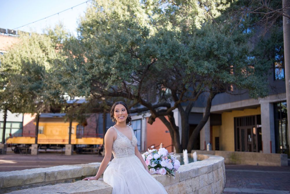 quinceanera sitting down. train in the back. pink dress and flowers. The Pearl. San Antonio, Texas. Wedding photographer