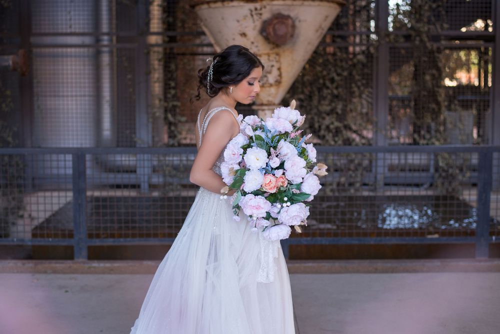 girl looking down to her bouquet. pink dress and flowers. The Pearl. San Antonio, Texas. Wedding photographer