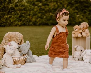 baby girl playing with teddy bears in the garden