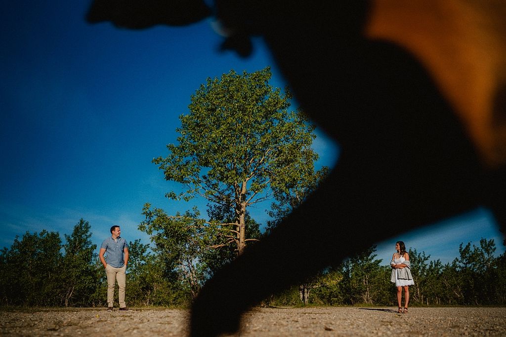 People enjoying a sunset moment on a hilltop with dramatic shadows.