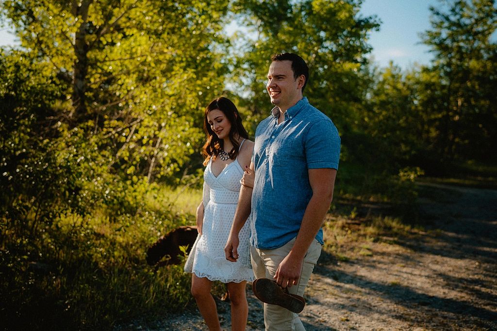 A romantic afternoon photoshoot on a sandy path surrounded by green trees.