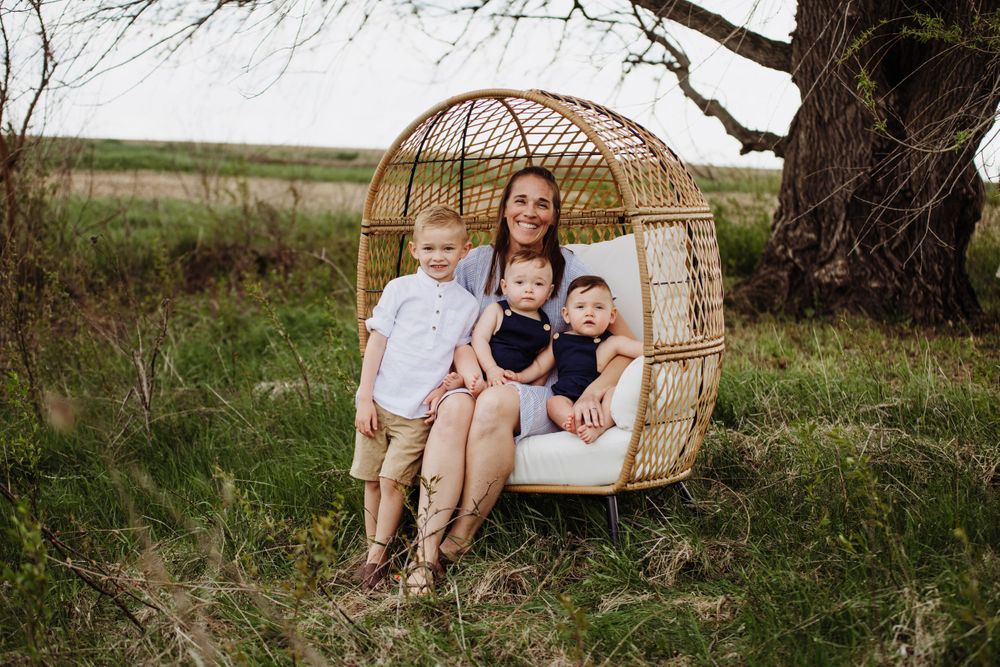Cozy outdoor scene with a suspended wicker egg chair against a natural landscape.