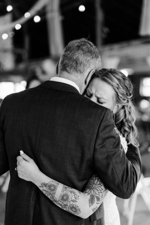 A black and white intimate dance moment captured under twinkling lights.