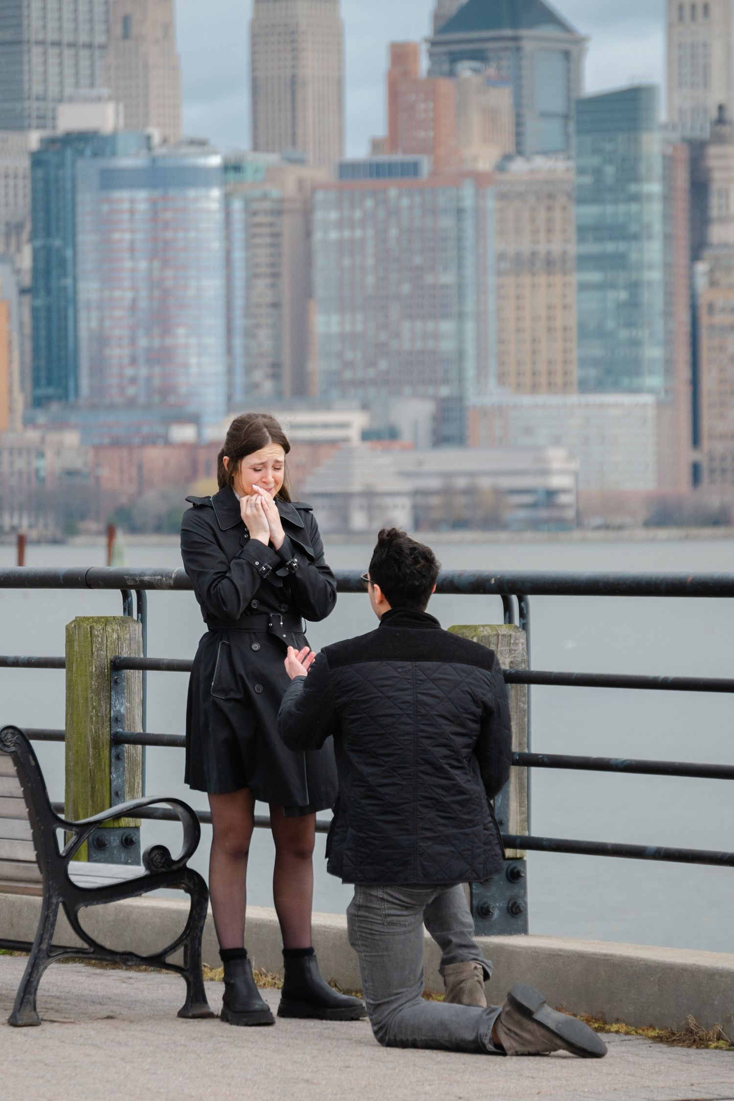 Liberty State Park proposal with woman crying while man proposes to her on one knee with hand extended