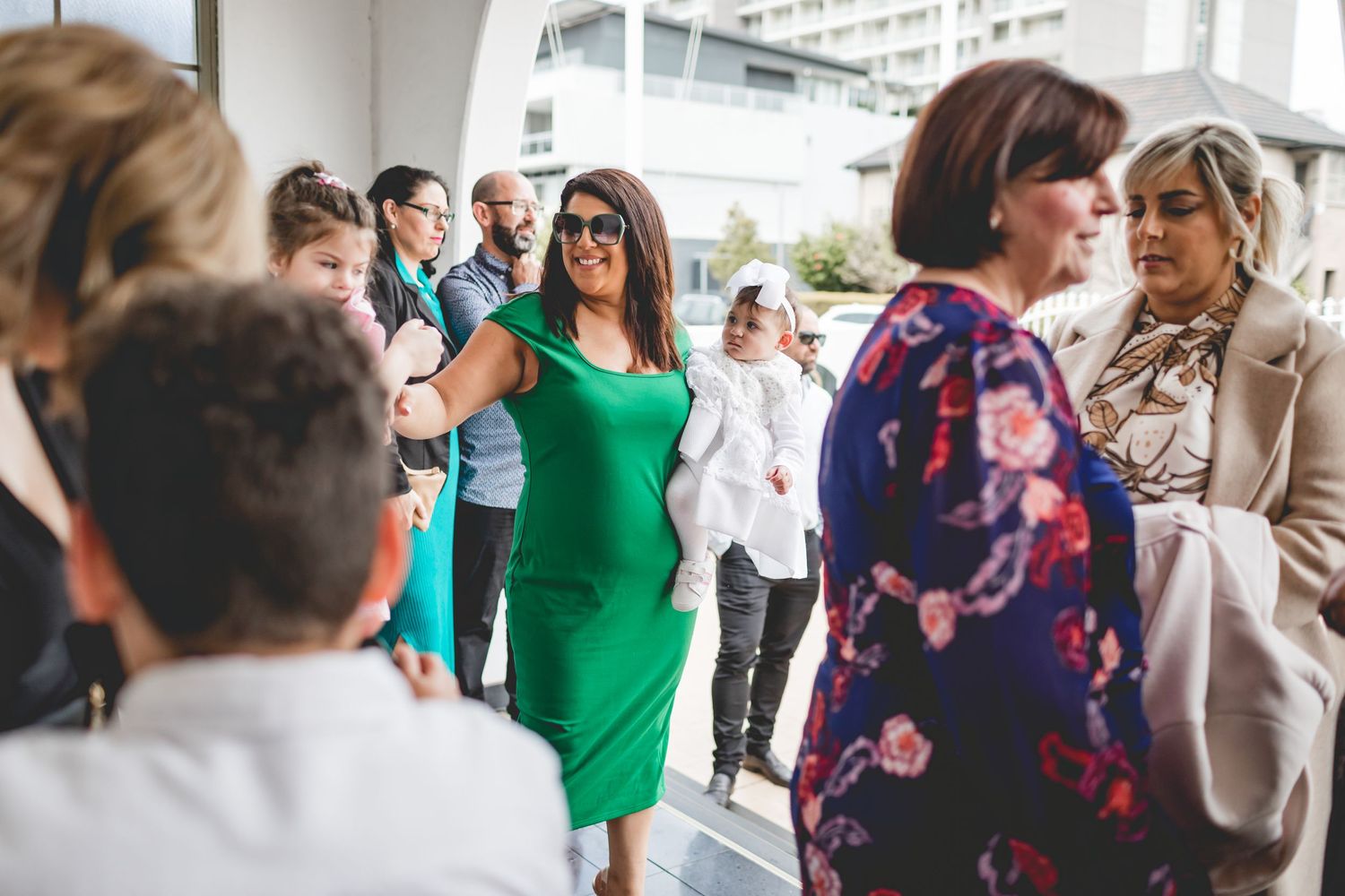 Guests mingling at an outdoor event wearing bright spring dresses and formal clothing.
