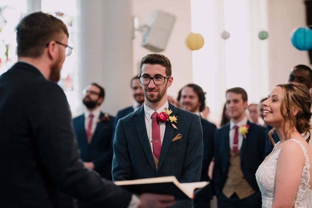 A wedding ceremony taking place in a church interior with decorative lanterns.