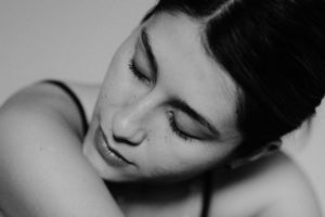 Intimate close-up black and white portrait showing peaceful expression.