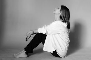 Artistic black and white portrait in white shirt against minimal background.