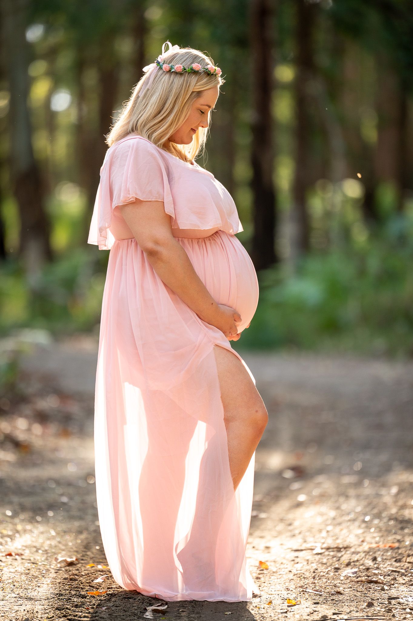 Mum to be looking at her baby bump in the bush