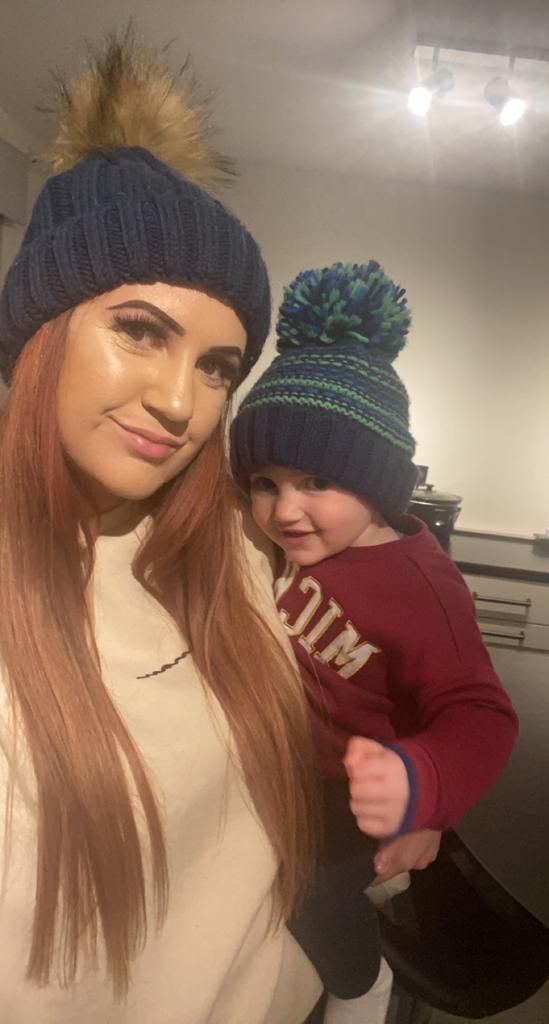 Mother and son wearing wooly hats smiling for a photo by photographer in DN7.