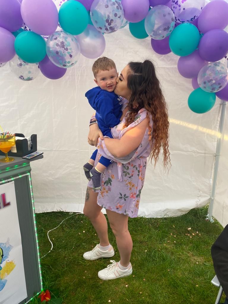 Mother kissing sons cheek at birthday party by photographer in Doncaster.