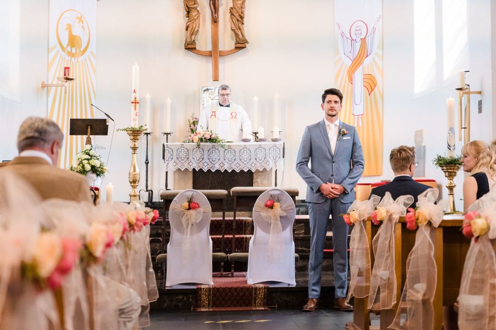 Bräutigam steht am Altar und wartet auf den Einzug der Braut in Sankt Barbara in Rurberg