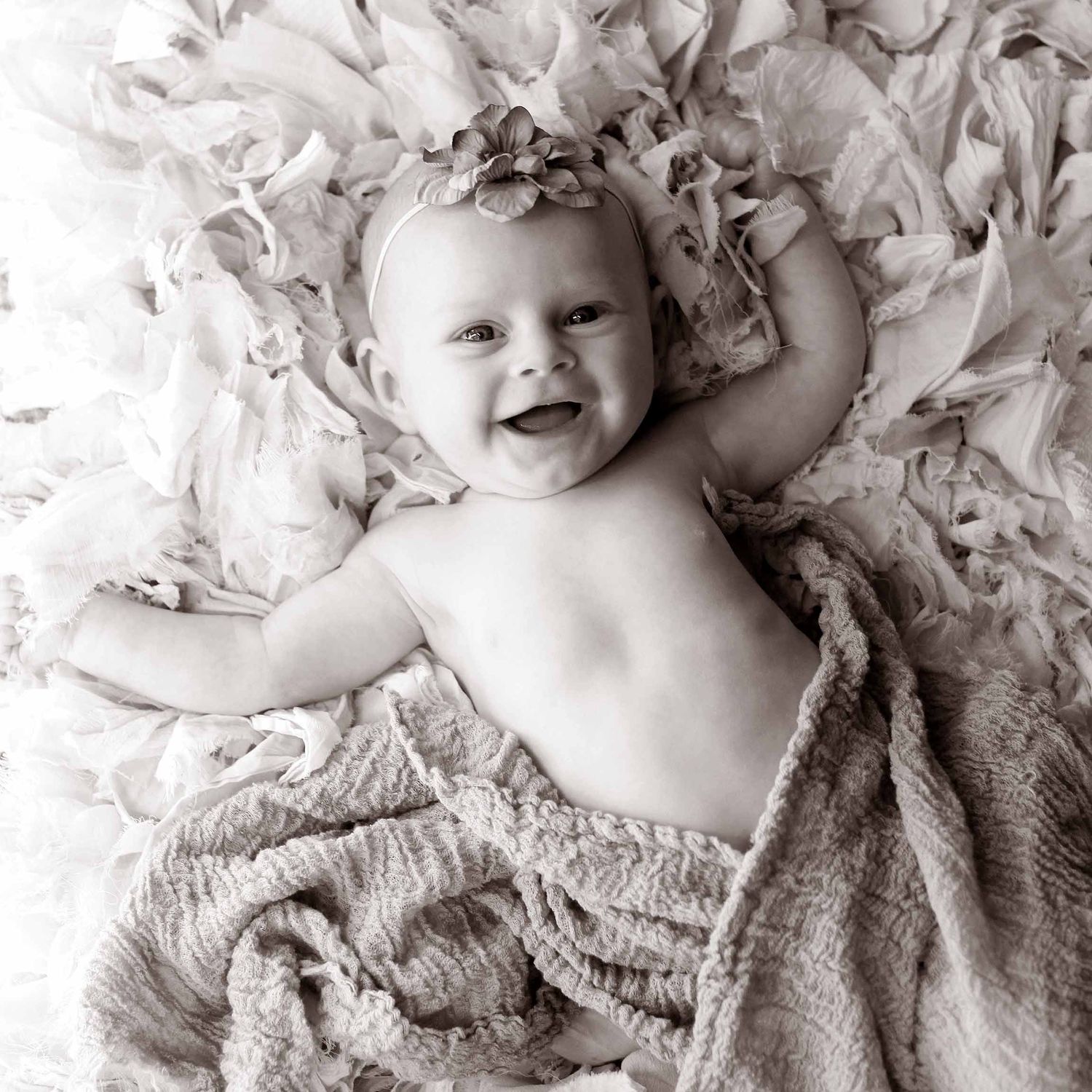 Black and white photo of newborn smiling by victoria leigh photography