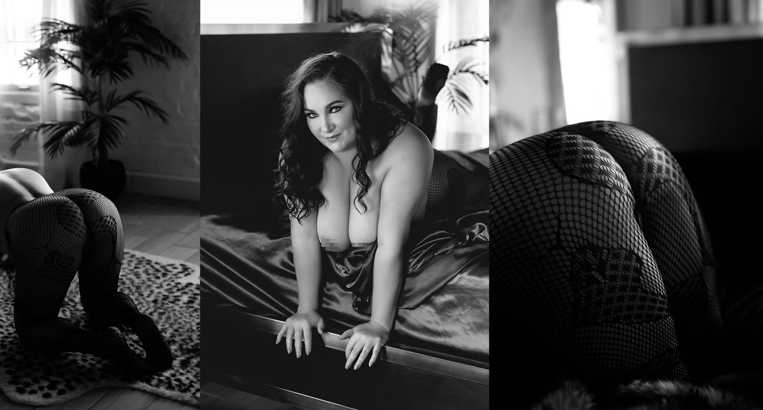 Black and white boudoir photograph showing sensual poses on a hardwood floor in dramatic lighting.