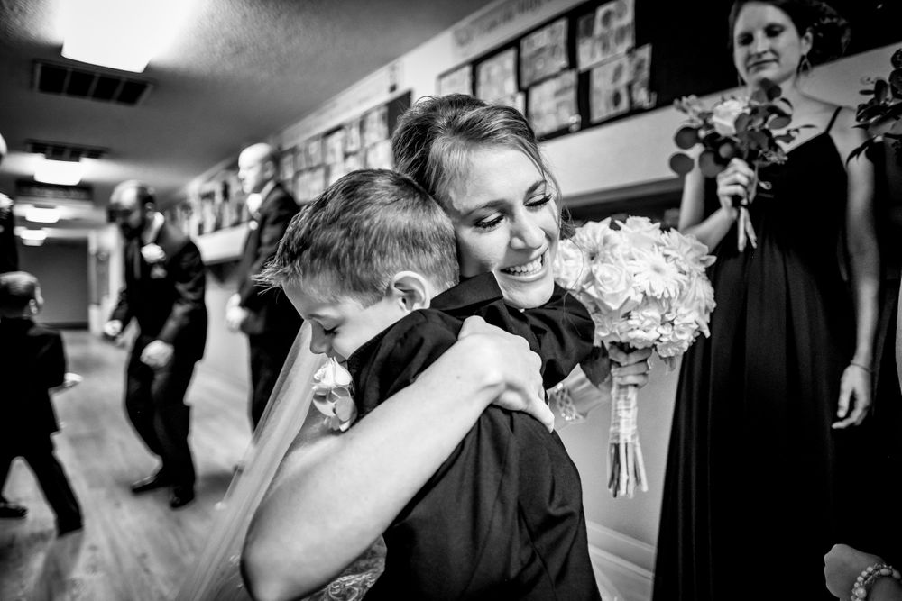 bride and ring bearer hug in Dallas, Texas