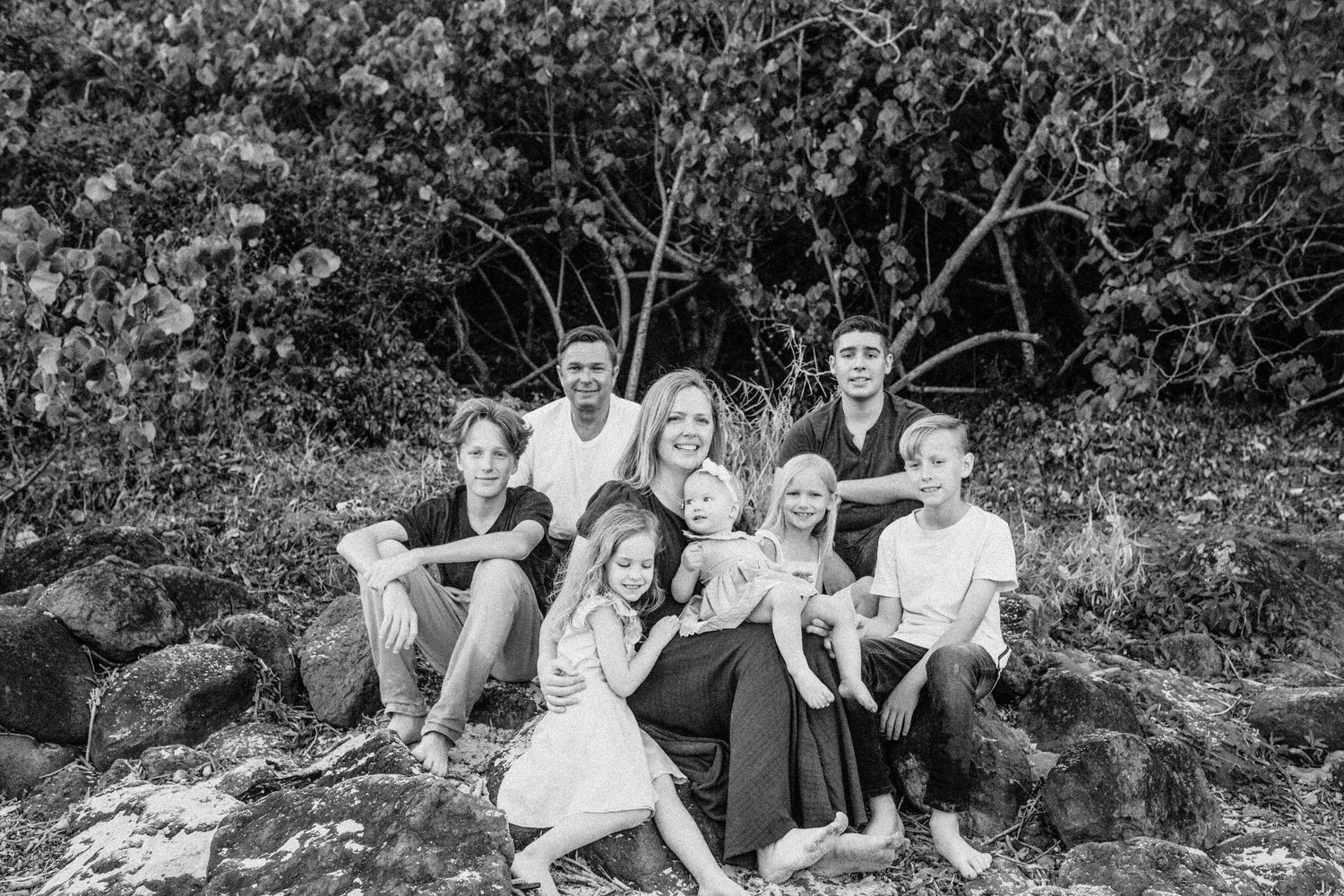 Black and white photo of a large family sitting together, capturing a heartwarming family moment on the gold coast