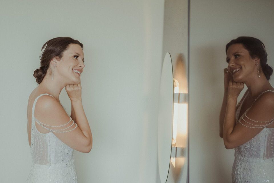 Momentos espontâneos dos preparativos captados sob uma suave luz natural durante os preparativos para o casamento.