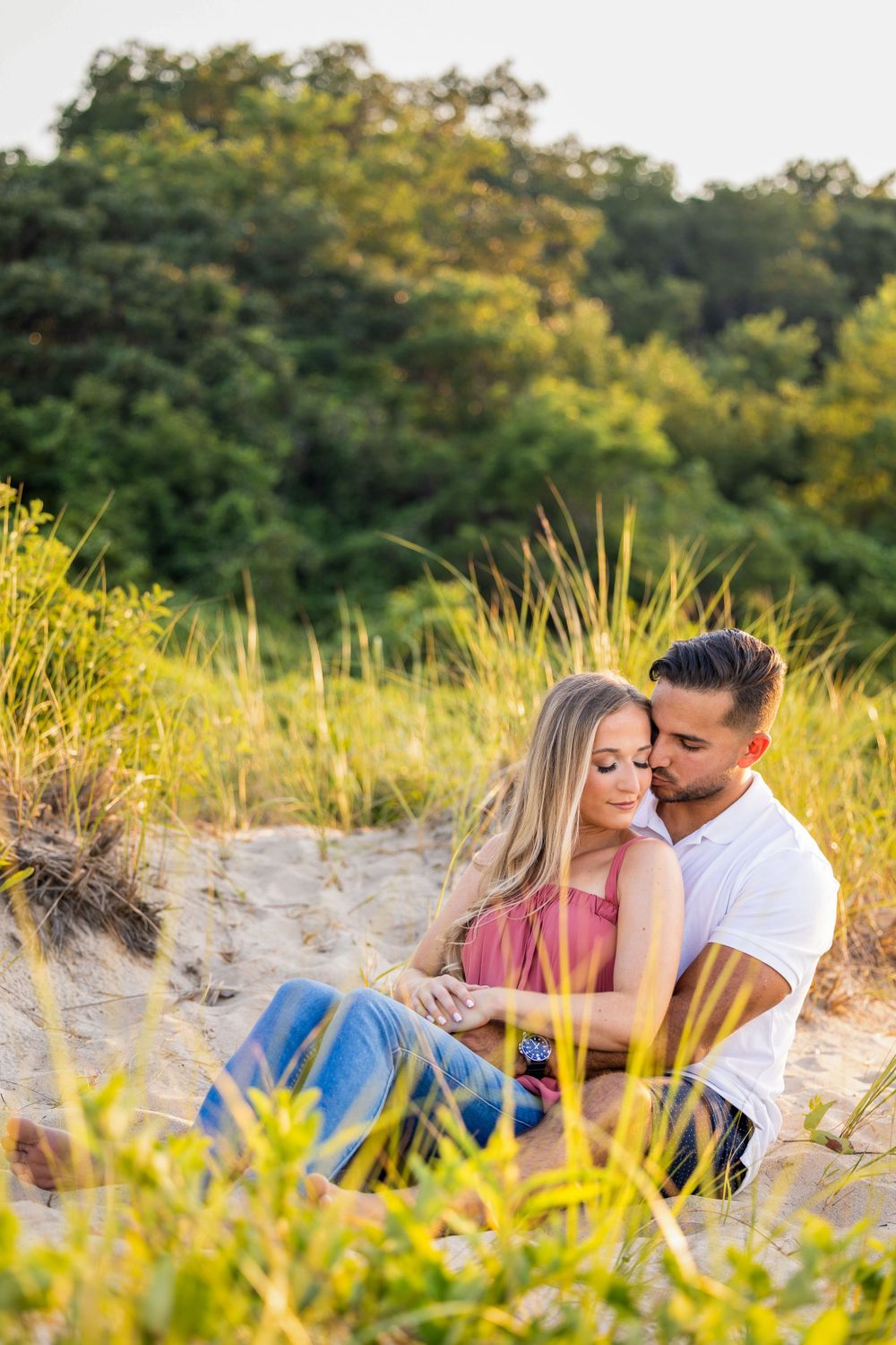 Tender moment captured on sandy dunes surrounded by summer beach grass.