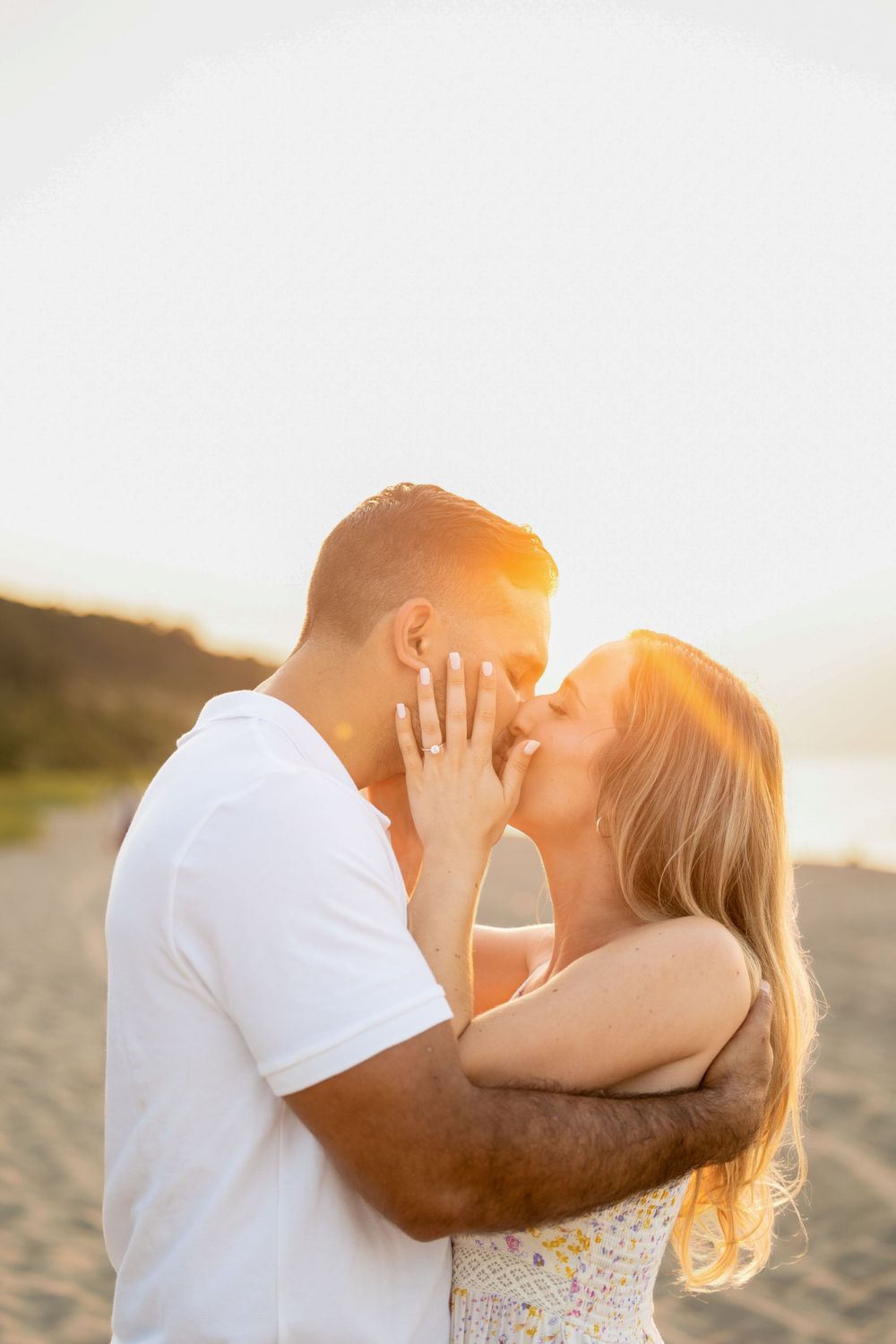 An intimate moment captured between a couple during golden hour on the beach.