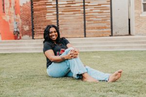 Casual outdoor portrait session in park with subject sitting on grass.