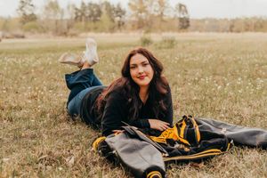 Someone lies in a wildflower meadow wearing denim with a backpack on a sunny autumn day.