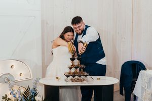 Wedding couple sharing a romantic moment at their reception table with floral centerpieces.