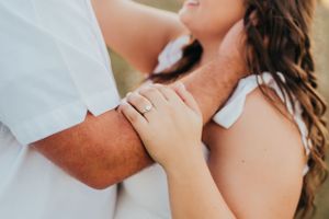 Close-up of hands gently embracing during intimate moment.