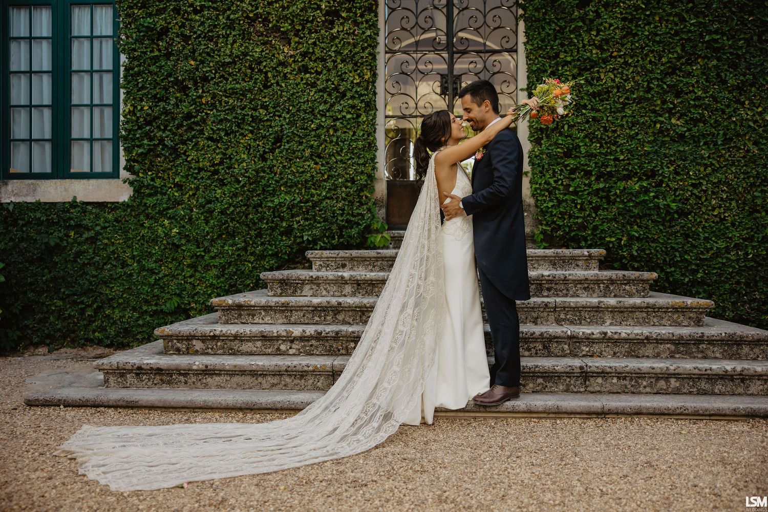 Black and white wedding portrait showing tender moments between couple in natural setting.