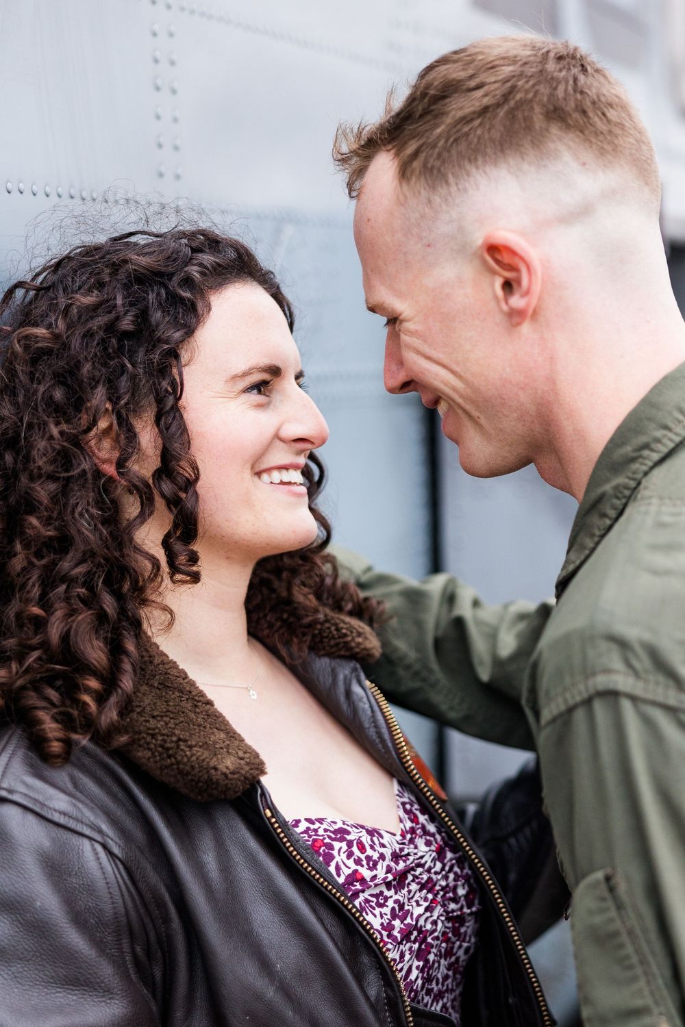 A loving couple shares a romantic moment together against an industrial metal background.