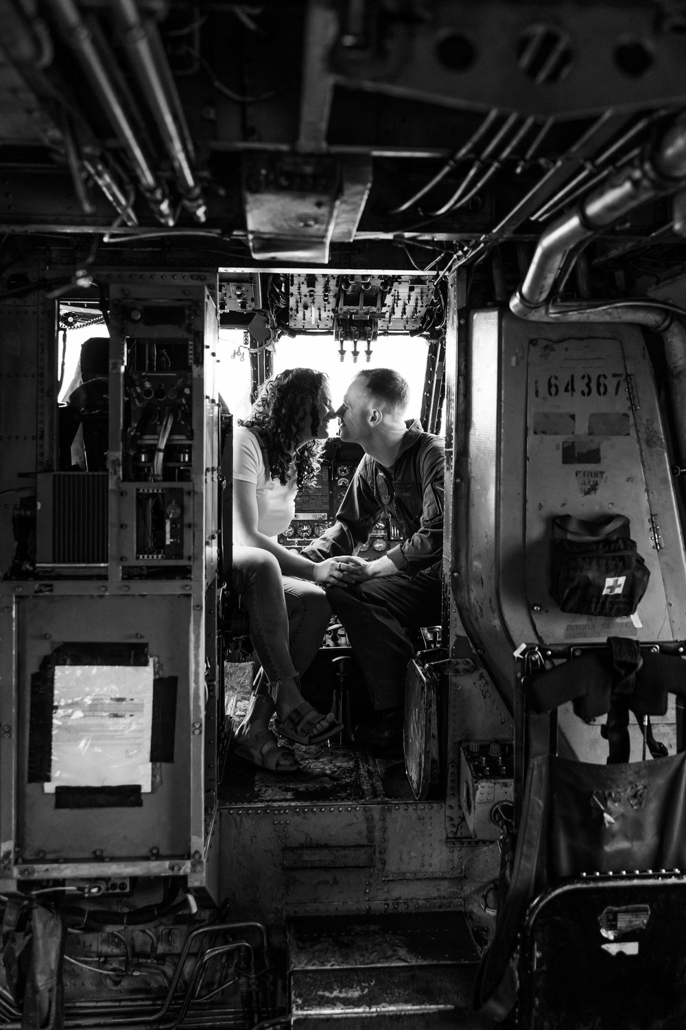 Black and white photograph showing military personnel working in a submarine control room with equipment and displays.