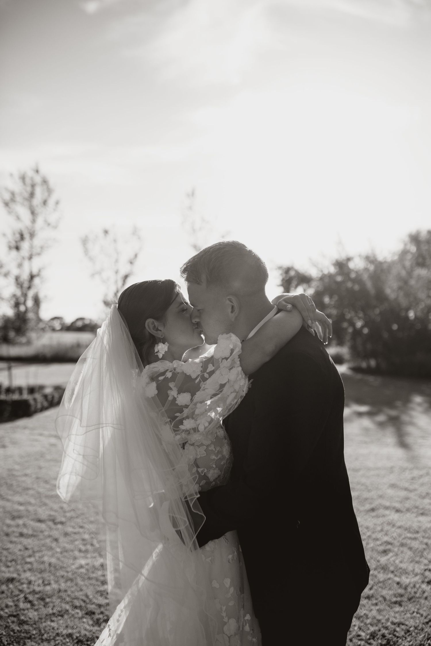 Romantic wedding portrait of a couple standing in front of a historic stone church.