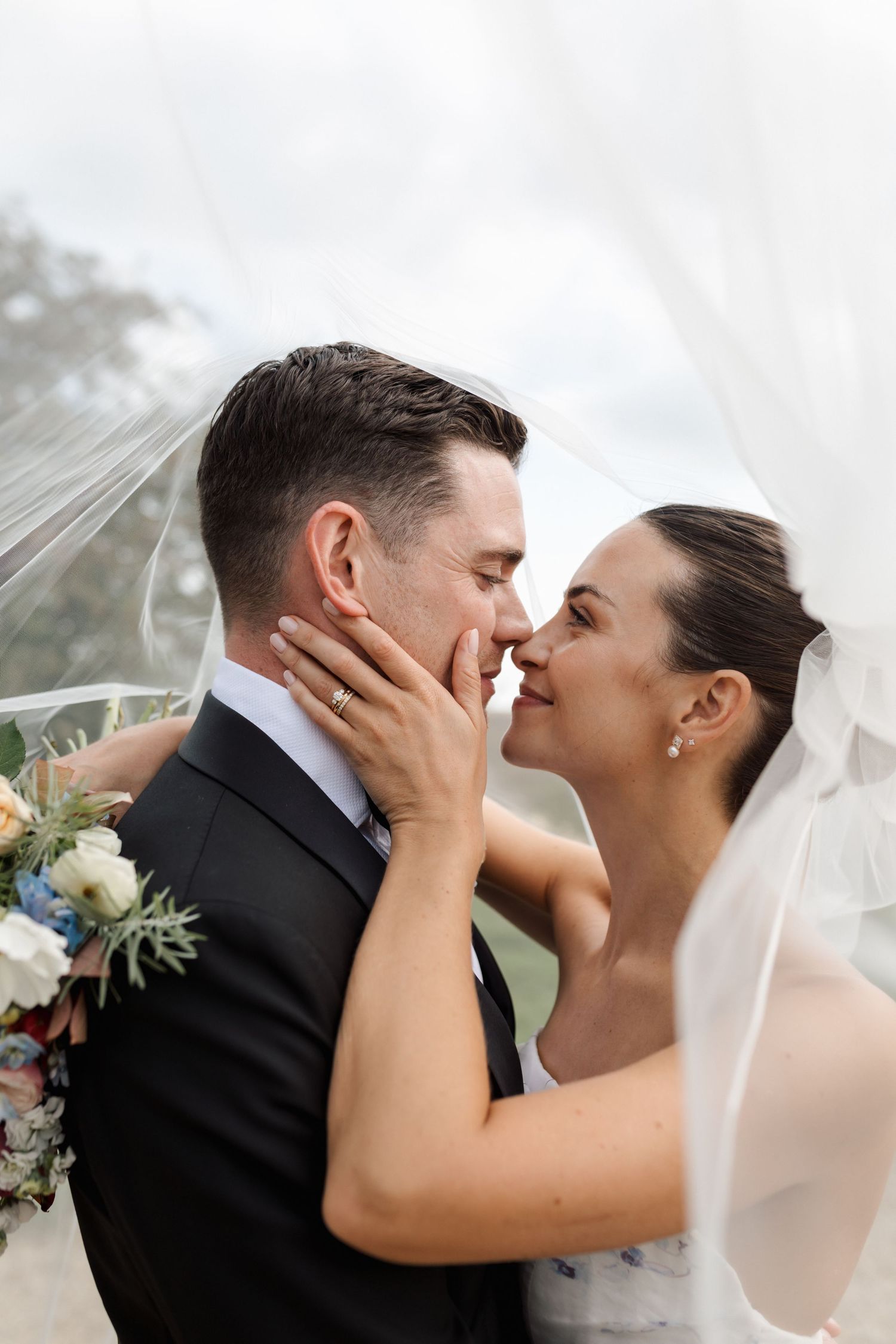 Black and white intimate portrait of newlyweds sharing a tender moment under a veil. old gore barn cirencester