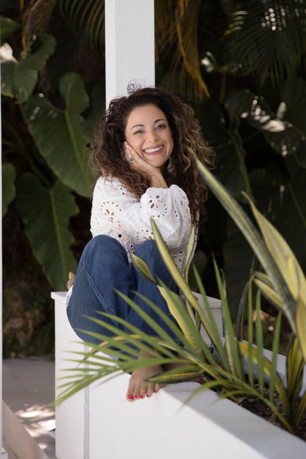 White eyelet top portrait among tropical foliage and palm leaves.