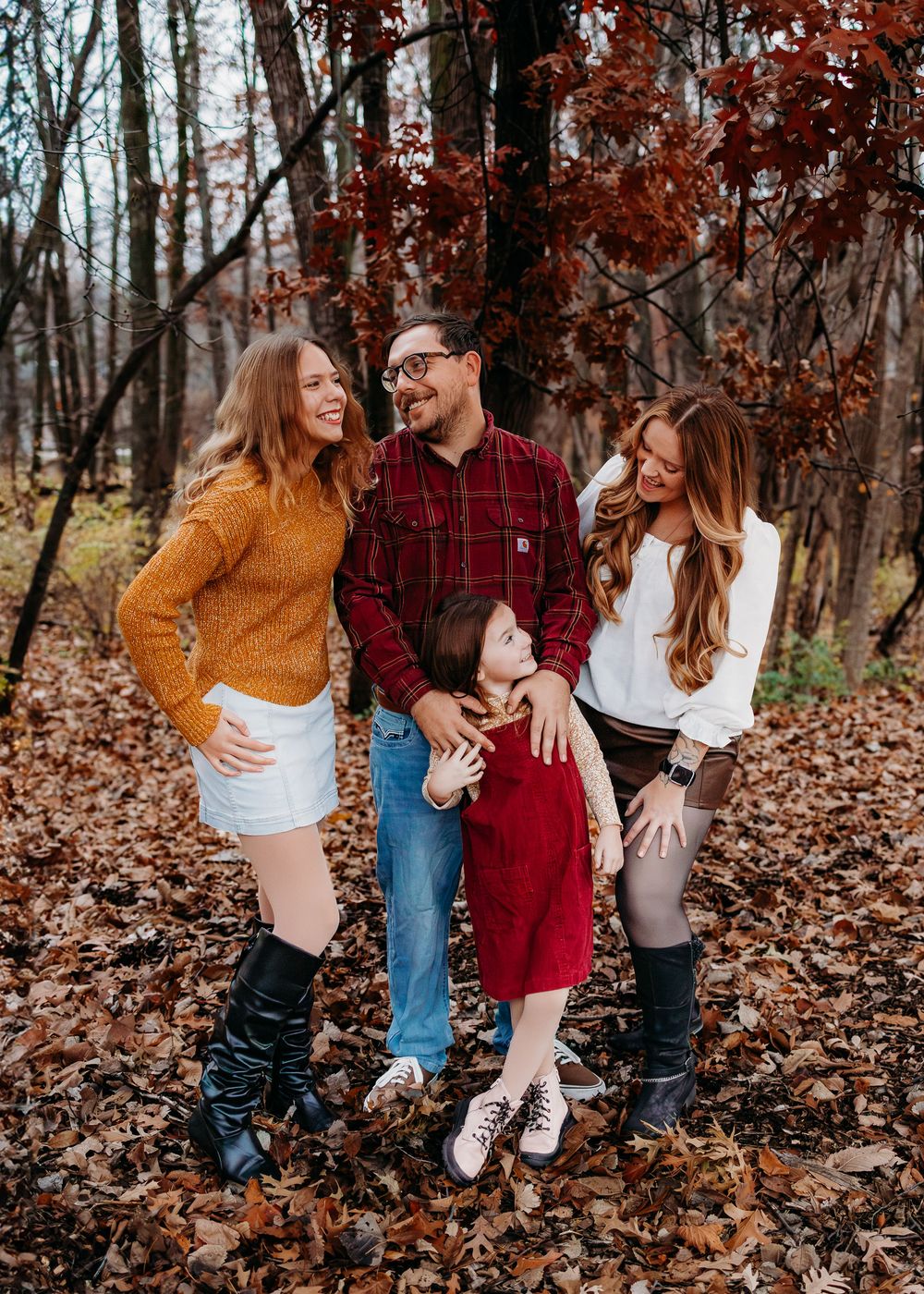 A family of 4 all smiling and laughing together.