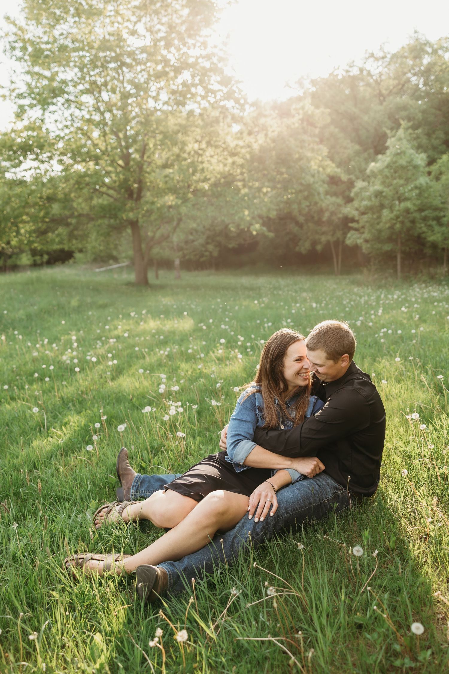 Romantic couple embracing against brick wall in urban setting.