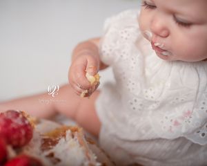 Baby eating cake at first birthday photoshoot Lexington, SC; photography studio children's pictures; Cake Smash Session