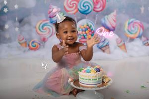 Smiling & clapping one year old baby girl wearing birthday dress with pastel smash cake & pastel-themed Cake Smash Session; SC photography