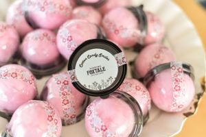 Pink chocolate candies with decorative patterns arranged in rows.
