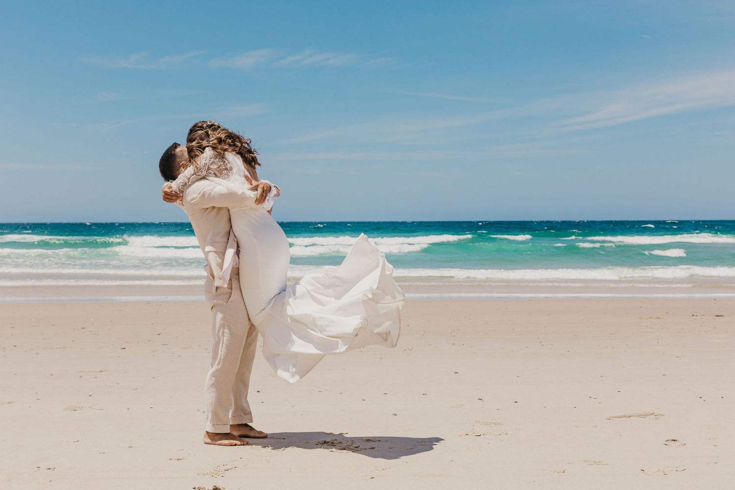 Bride running into the ocean after a beach wedding at sunset, photographed by a Byron Bay wedding photographer on the coastline of Byron Bay