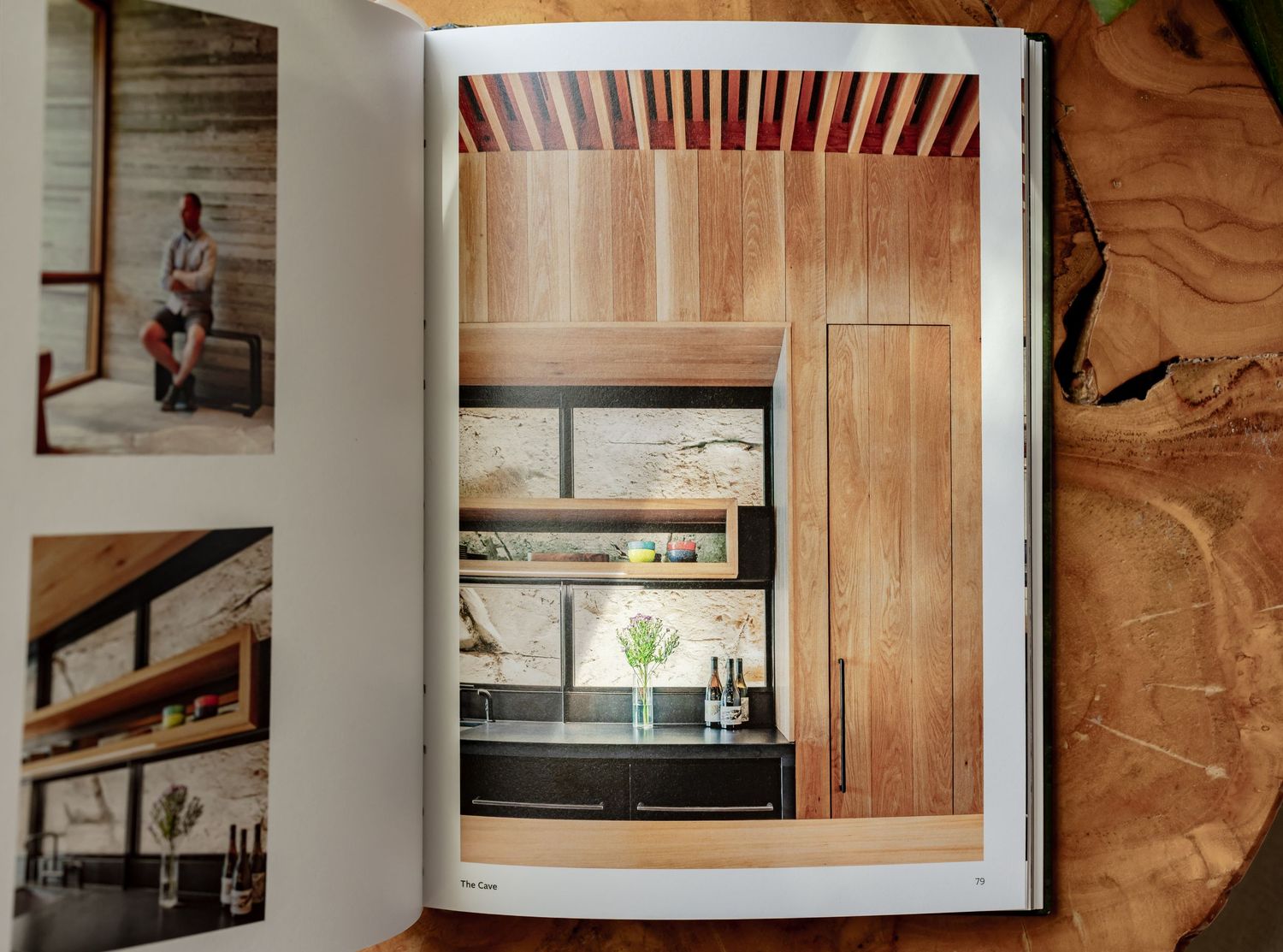 Open book displaying modern interior design featuring warm wood cabinetry, built-in shelving, and sleek kitchen details.