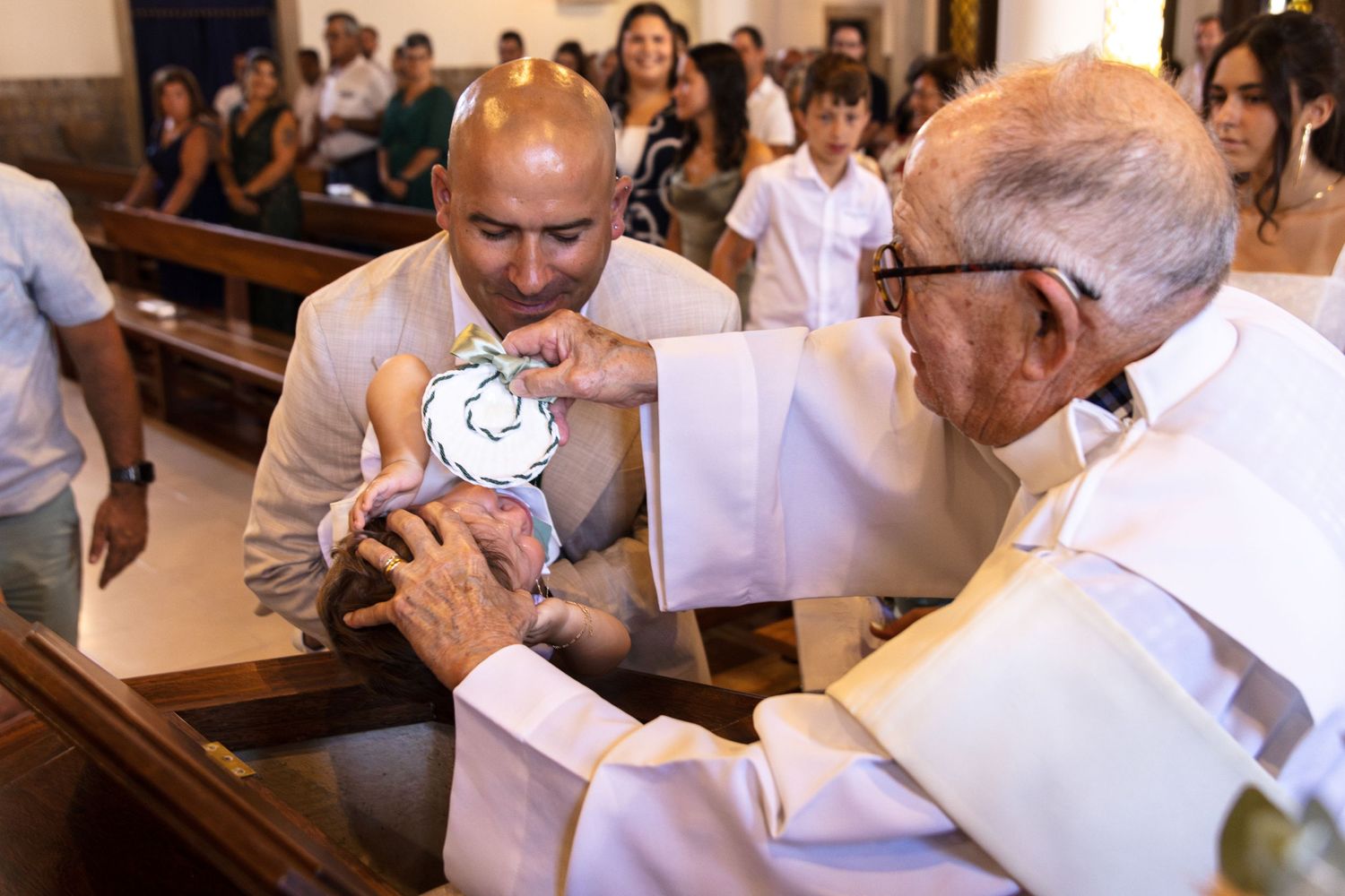 People gathered in white attire inside traditional church with wooden pews.