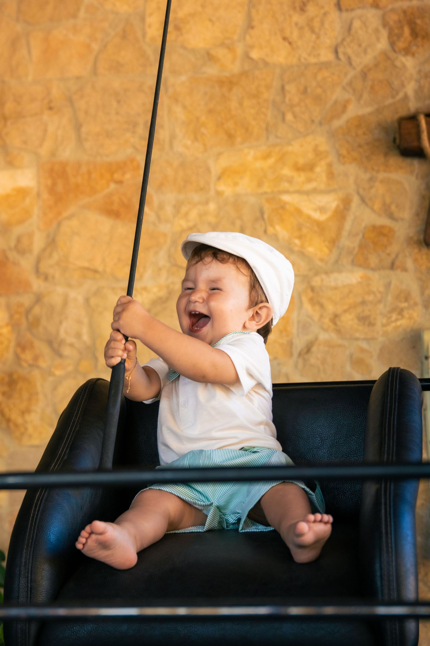 Baby sitting in black leather chair showing various expressions.