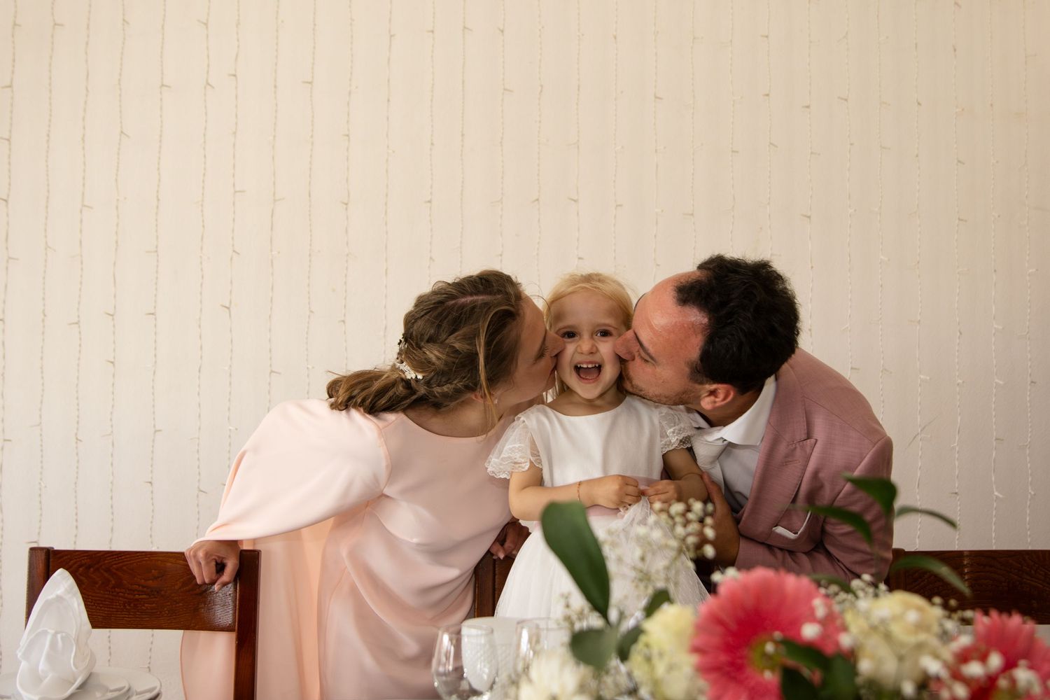 A tender family moment captured indoors with soft lighting and floral decorations.
