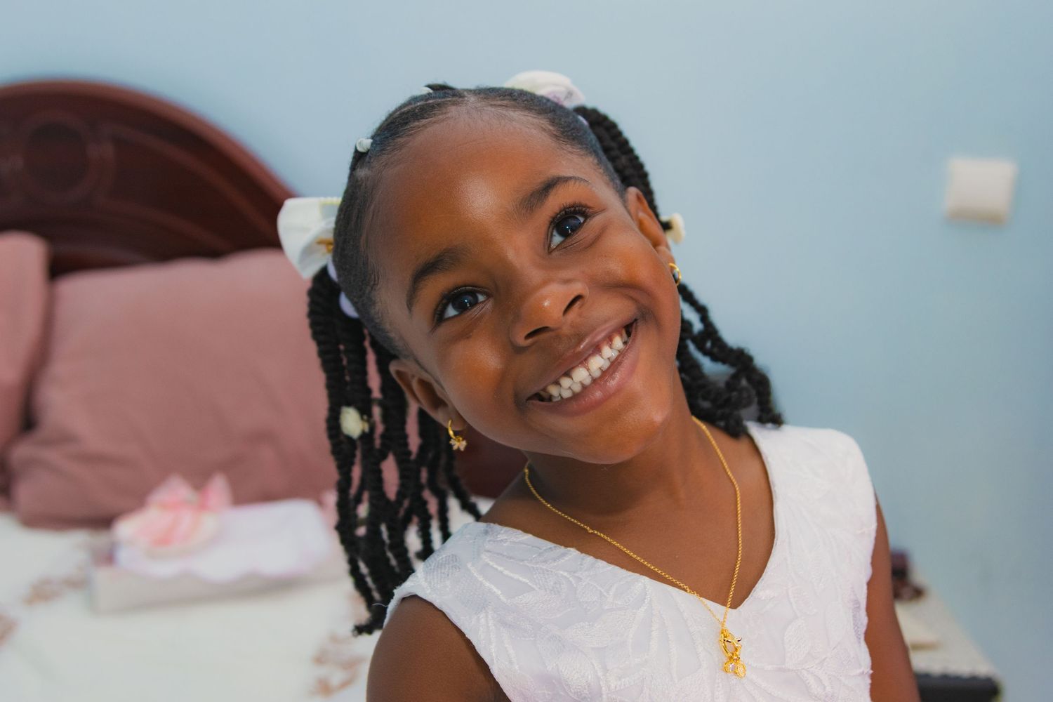 A series of candid smiling portraits showing joyful expressions and braided hairstyles.