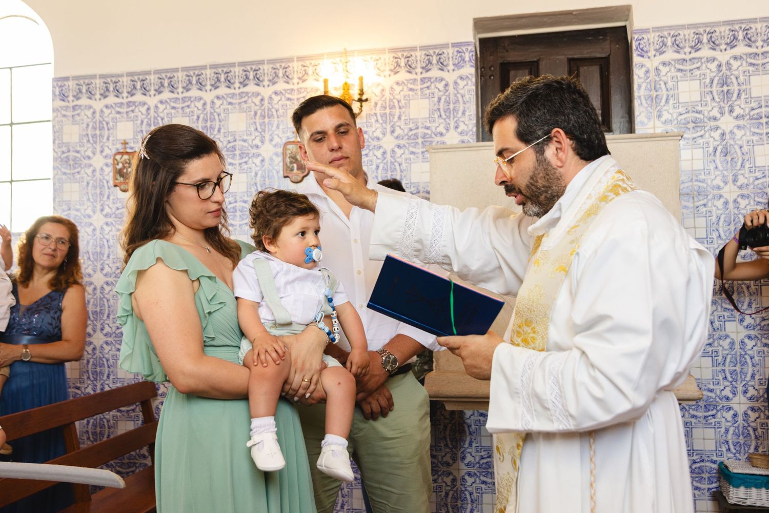 Religious ceremony taking place in a church with decorative tile walls.